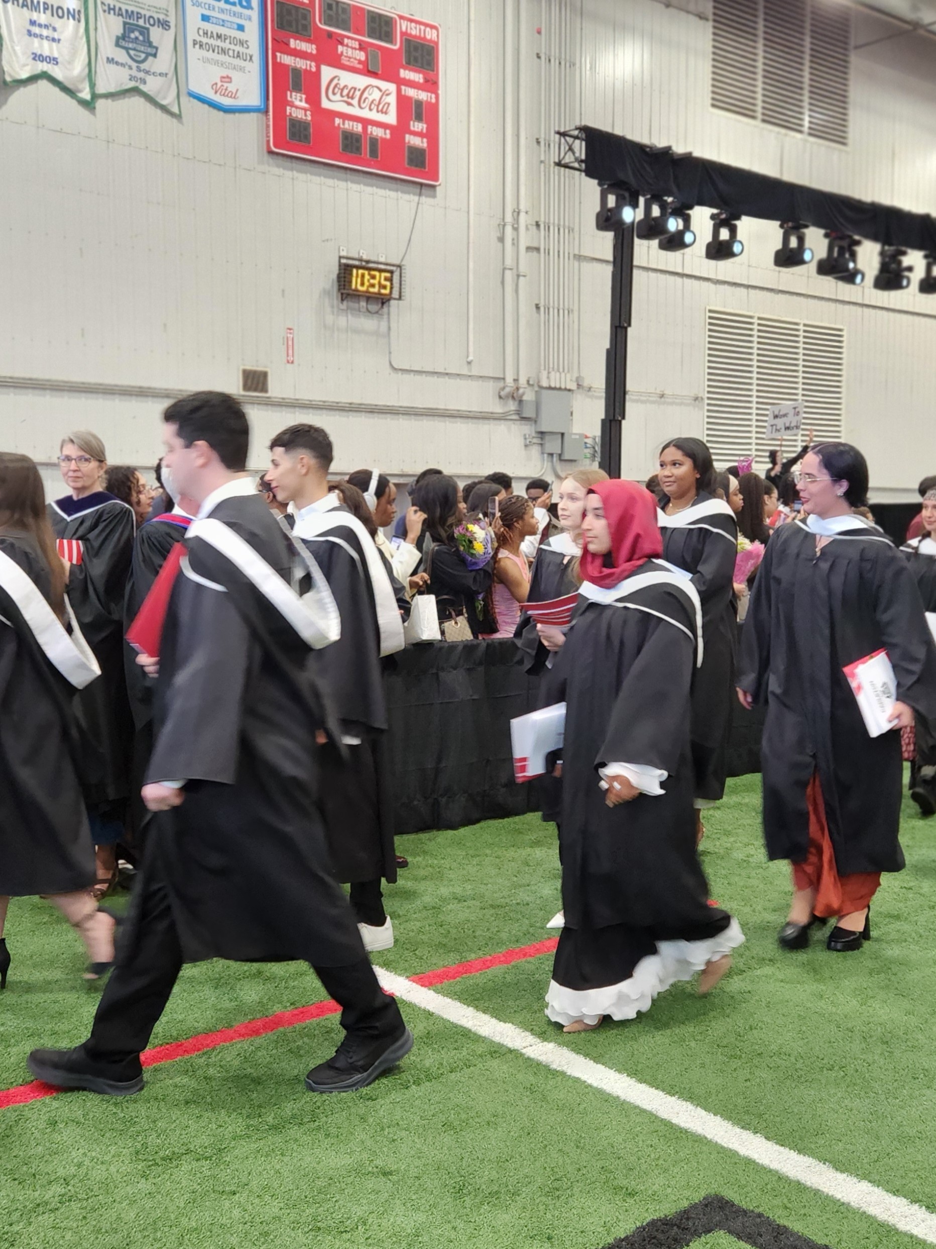 Image of a graduate, Fatima, walking at convocation