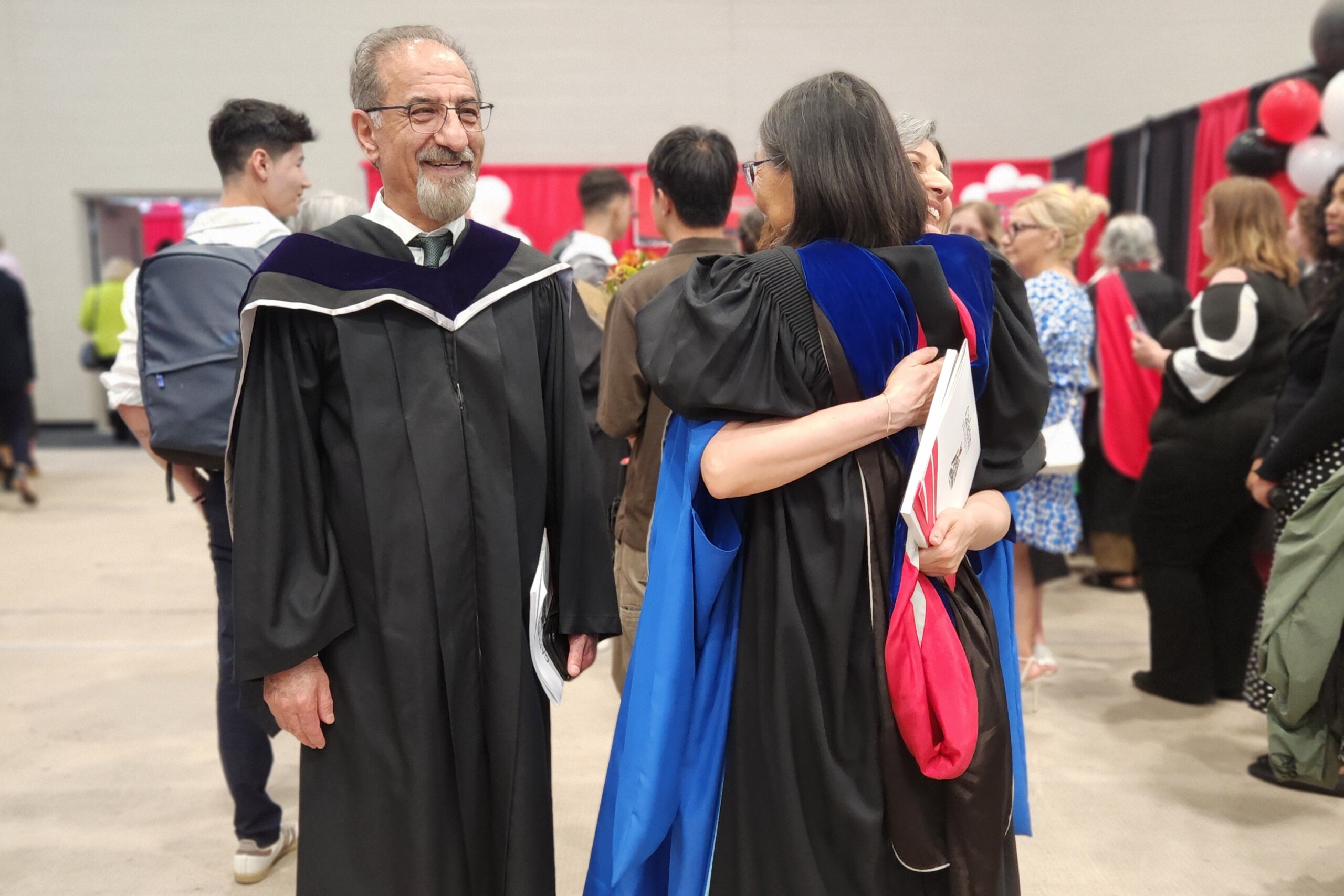 Image of a graduate, Hamideh, with two professors at convocation