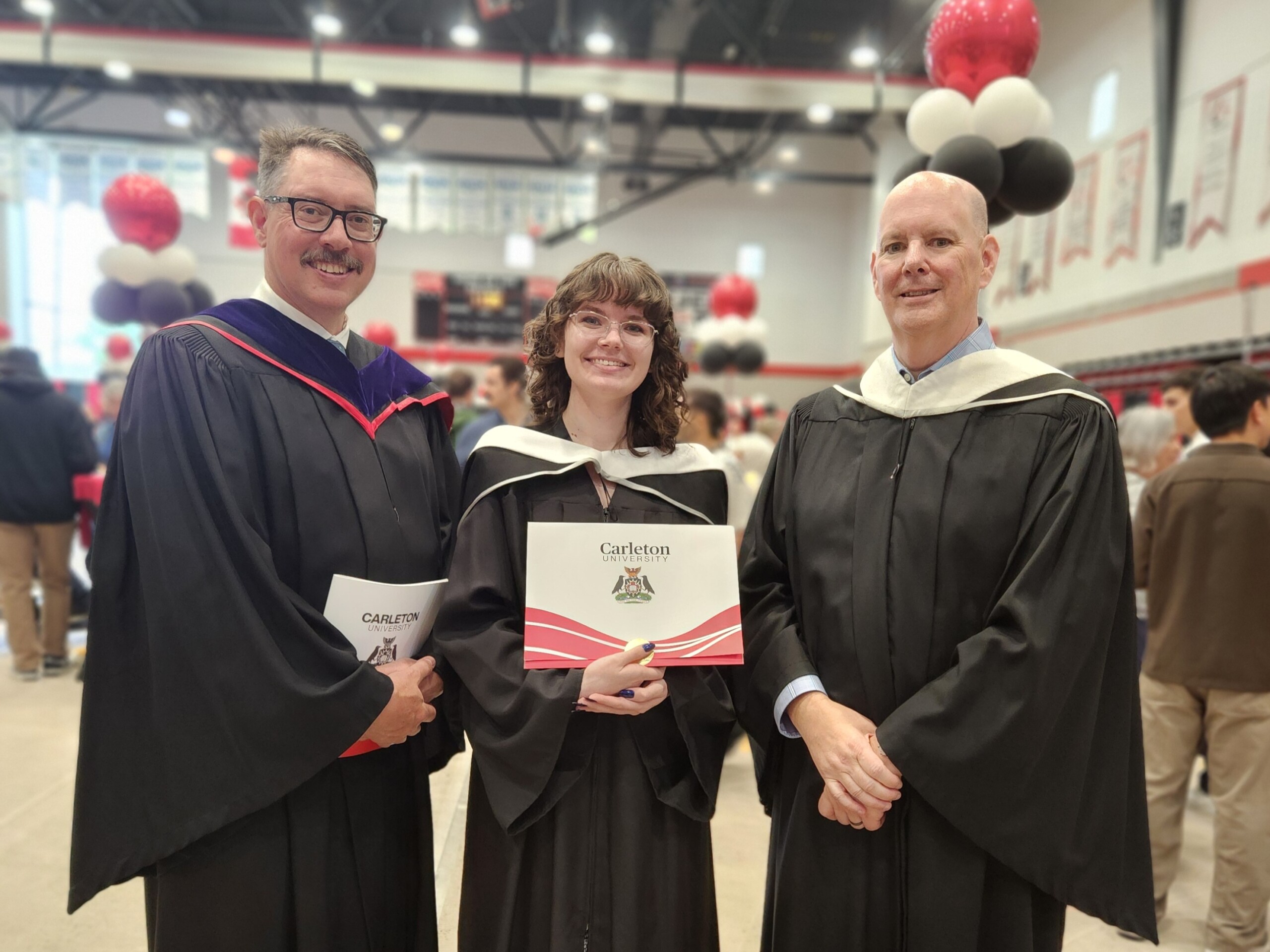 Image of a graduate, River, with professors Michael Rodgers and Don Myles