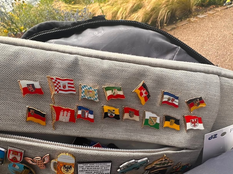 Backpack shows 16 pins collected by Thomas.