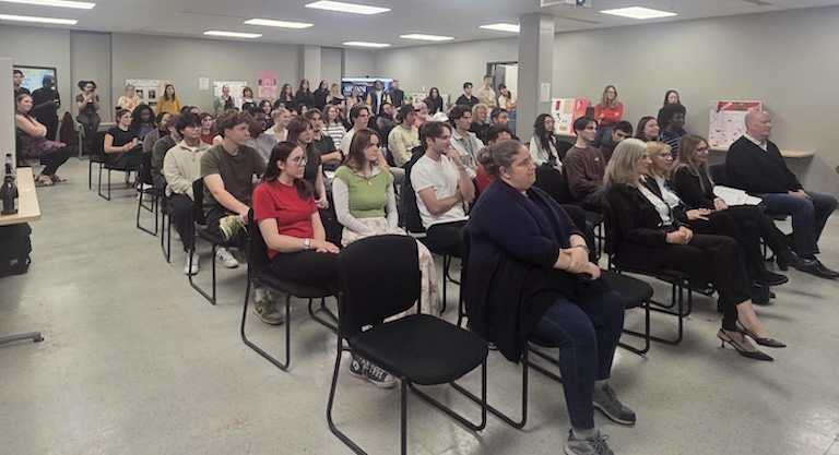 Group of 60 people sitting in audience.