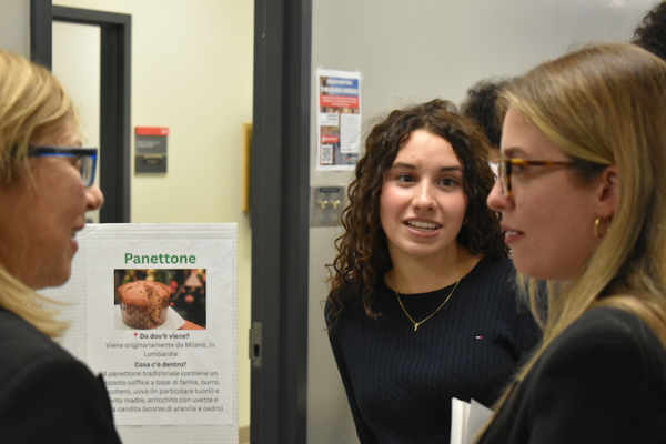 Mia and Rebecca chat about panetone on her poster about La Dolci Italiani.