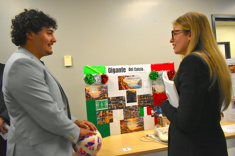 Markel dressed in a suit shares his love of soccer with Rebecca
