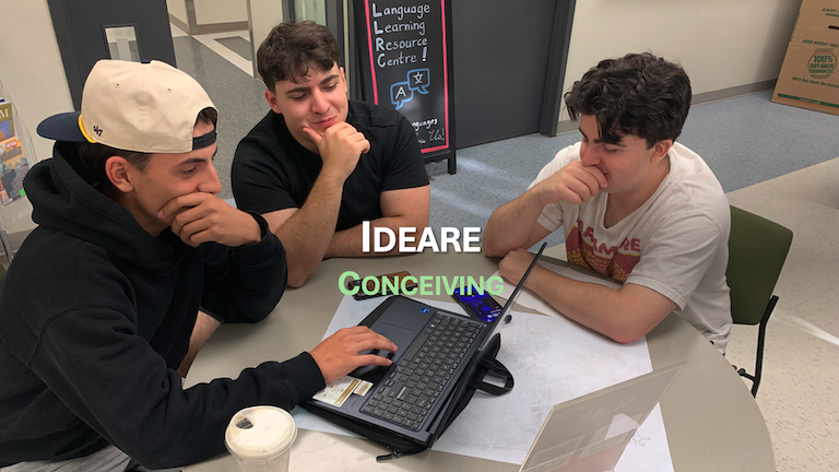 Three guys sitting around a laptop looking pensive. Ideare - Conceiving.