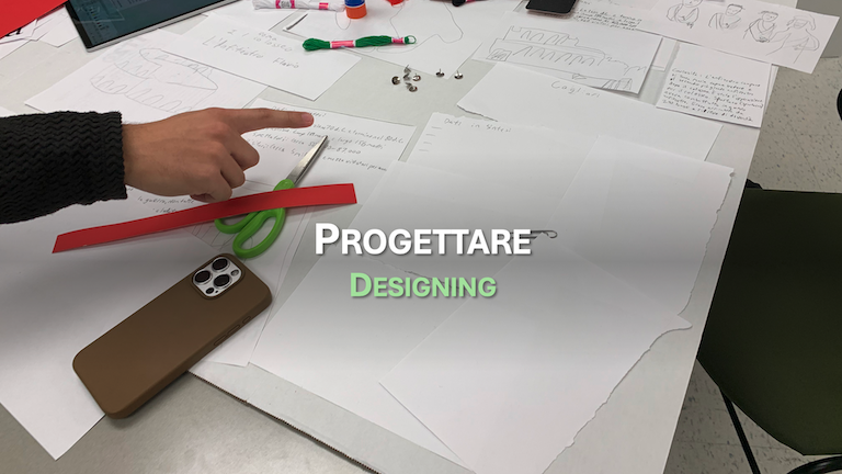 Finger pointing. Thumb tacks and thread on a table. Progettare - Designing.