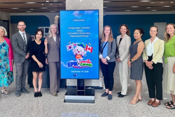 Delegation in front of sign: Welcome, Languages Canada and Canadian University. EPIK x Languages Canada