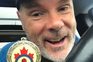 David Morton holding his Mixed Double Team Canada medal for Canada