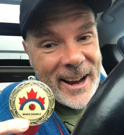 David Morton holding his Mixed Double Team Canada medal for Canada