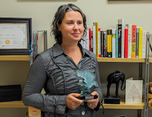 Julie in her office with her trophy