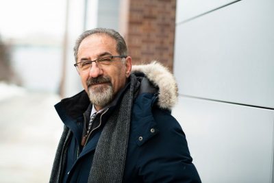 Jaffer in a winter coat smiles for the camera