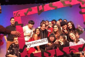 All performers inside bright pink picture frame decorated with musical notes.