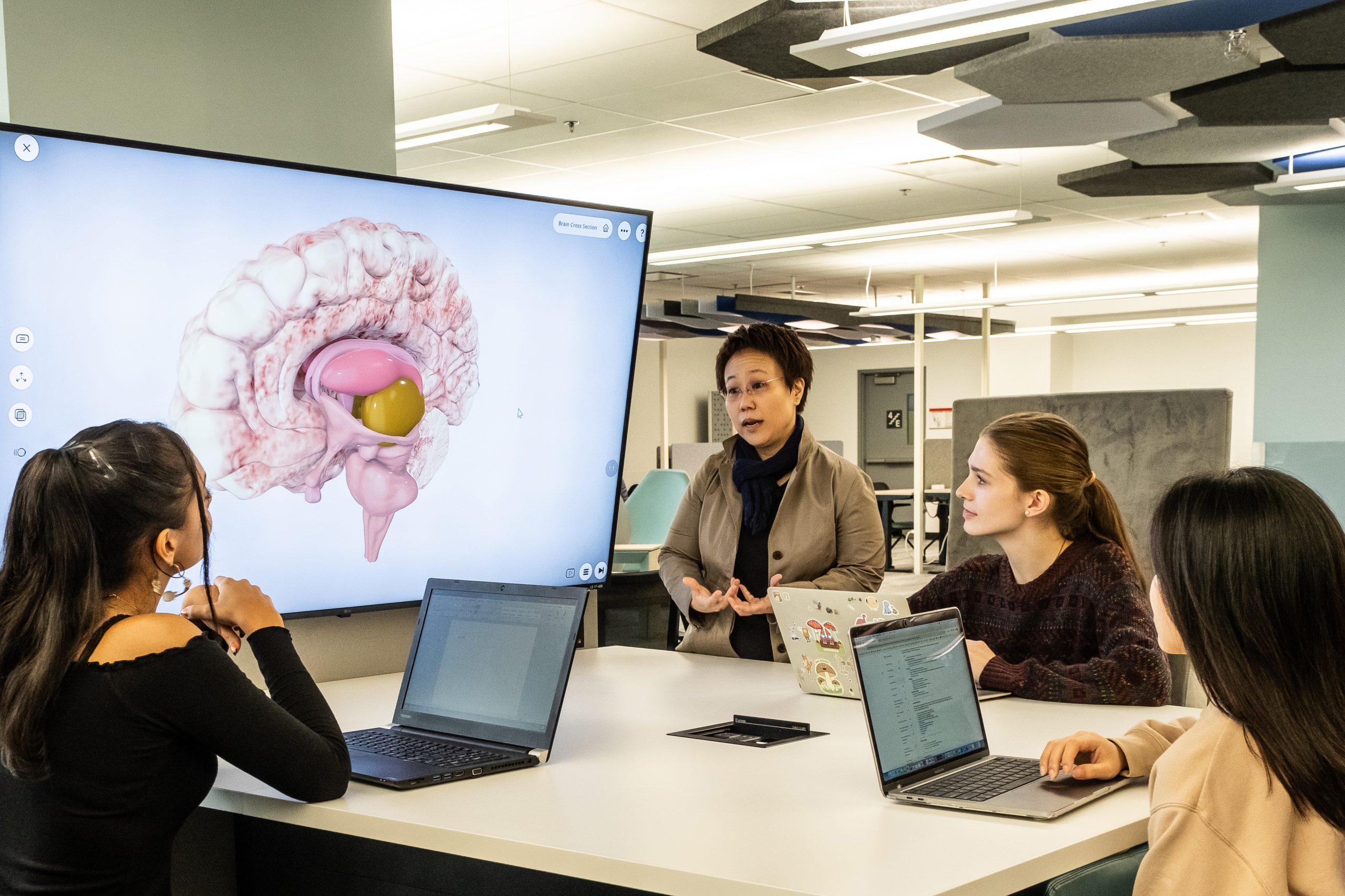Dr. Masako Hirotani with three students, sitting around a desk