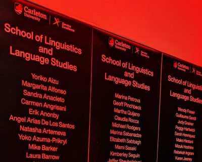 Three black signs listing all of the faculty, contract instructors and staff in SLaLS