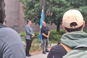 View of Michael Rodgers and David Morton with the flag in the background