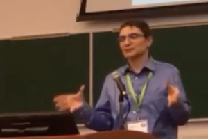 screenshot of Guillaume standing at the conference podium