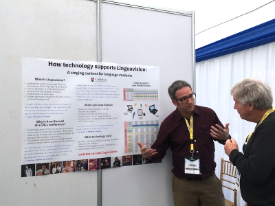 Mike displays poster to conference attendee