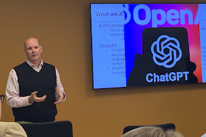 Don standing in front of the ChatGPT logo on his presentation.