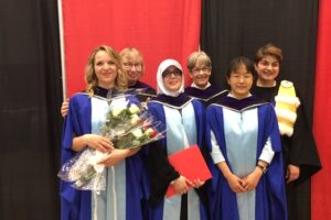 Chloe, Natasha, Nwara, Janna, Lin, and Eva in their graduation robes