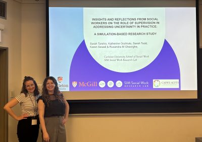 Katherine Occhiuto and Sarah Tarshis posing beside a screen reading the title of their presentation "Insights and Reflections from Social Workers on the Role of Supervision in Addressing Uncertainty in Practice: A Simulation-Based Study"