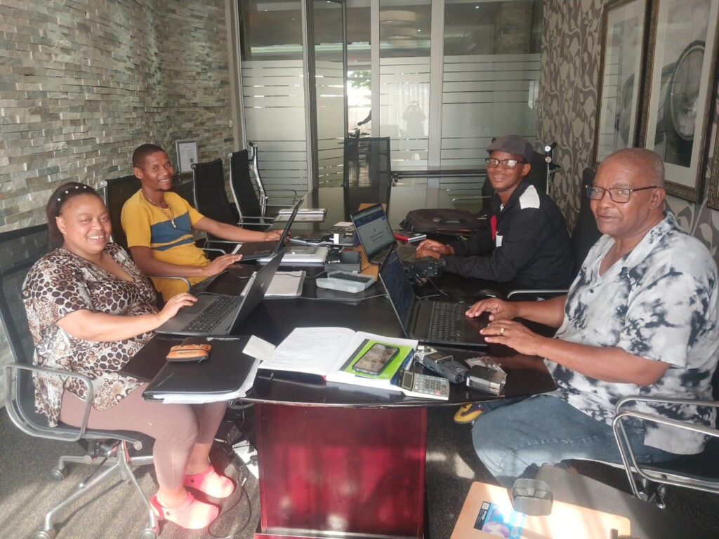 Image of Sharon Gabie, Wilard Veldskoen, Boetles Gewers, and James Mapanka organizing fieldwork materials.