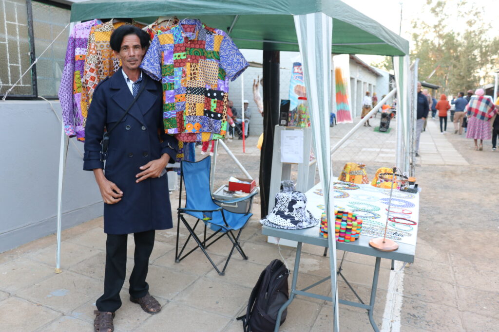 Romeo Joseph, a bead worker from Karasburg, Namibia, posing in front of his vendor stall.