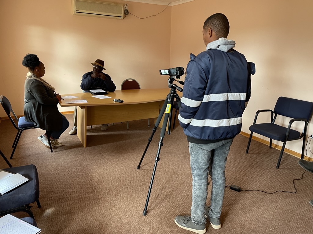 Wilard Veldskoen records an interview between Abraham Katimba and Sharon Gabie.