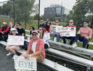 Image of 2023 Stoney Cup: Fans watching the game holding up signs to cheer players on and taunt opposing team