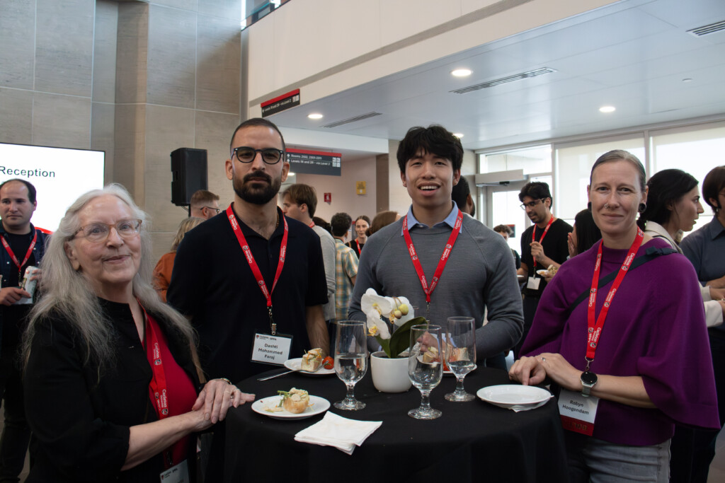 Guests pose for a photo around a cocktail table at the Alumni Reception.
