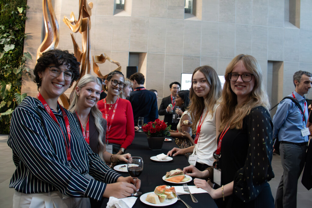 Five young adults smile for a group photo at the Alumni Reception.