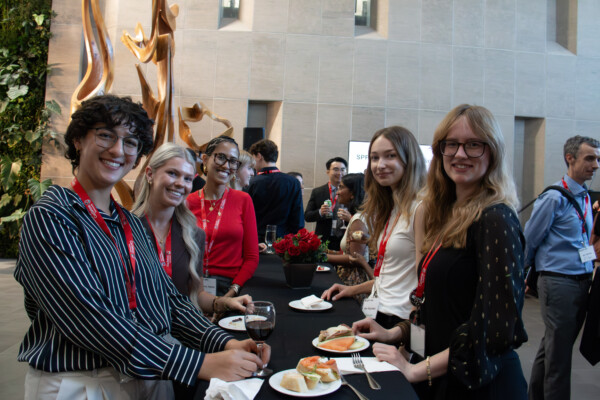 Five young adults smile for a group photo at the Alumni Reception.