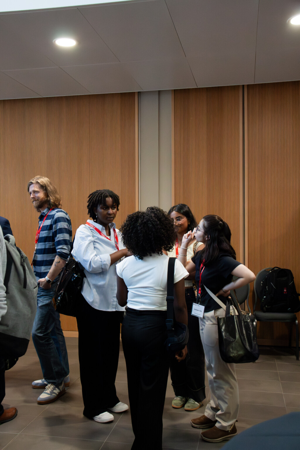 Several attendees wearing stand in small groups and converse during the SPPA Alumni Reception.