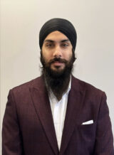 Photo of Mandeep Singh, wearing a burgundy tuxedo, black beard, and black turban