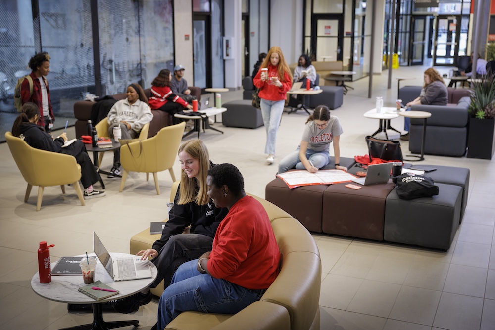 People seated throughout the Arcade at Rideau House, using tables and lounge seating to work and gather.