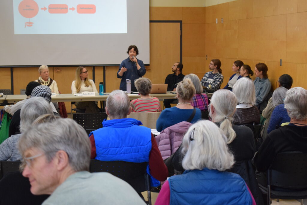 Woman speaking at a microphone in front of an audience