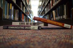 Three books on the topic of controversy lie on the floor of the library