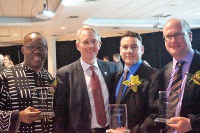 The three award winners hold their awards and pose for a group shot with Peter Ricketts
