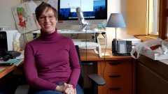 Deanna Whelan sits in her office in front of a desk