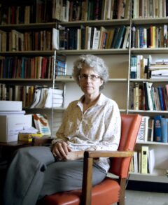 Prof. Dominique Marshall sites in front of bookcases filled with books