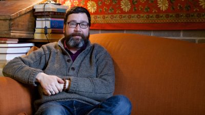 Gregory MacIsaac sitting on a couch
