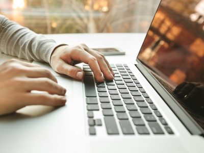 Hands typing on laptop