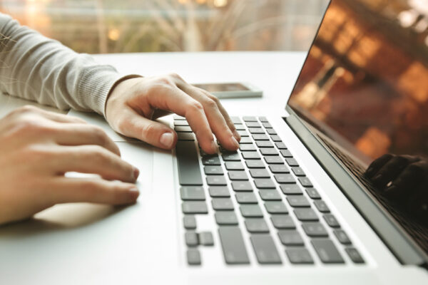 Hands typing on laptop