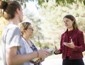 Instructor and two students chat outside