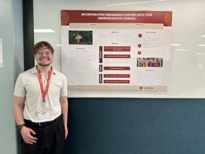 Sam Mallow stands with his project poster