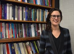 Vida Panitch stands in front of a bookshelf
