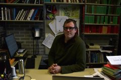 Zeba Crook in sits at his desk in his office