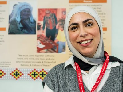 Student posing in front of a poster display