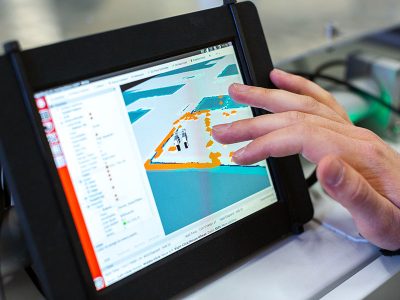 A person touches a tablet with a 3D rendering on screen.