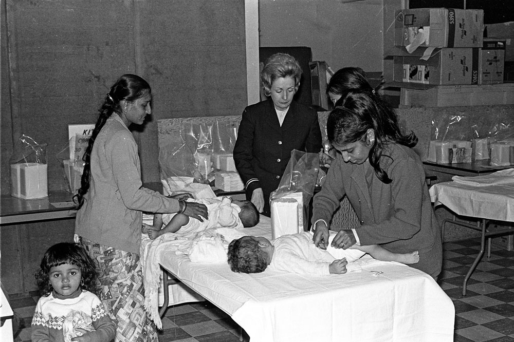 Lt. Carol McGinty working on Operation UGX assists some Ugandan mothers with their children in the nursery at the reception centre in Longue Pointe.