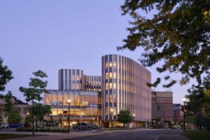 Photograph of the exterior building of the Sprott School of Business lit up in the evening