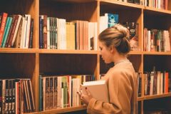 A women selecting books from a library shelf